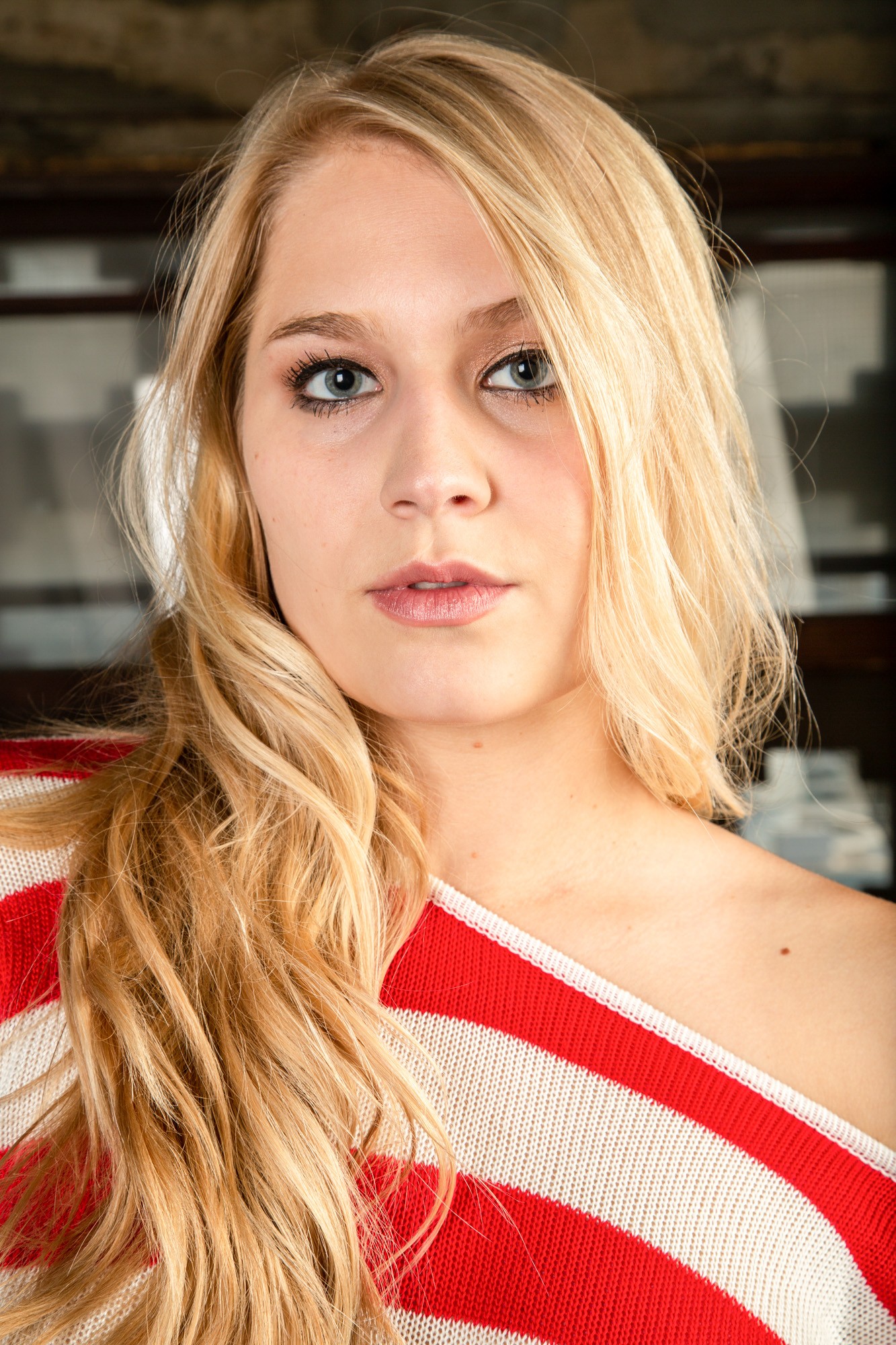 Blonde woman in red striped top, studio portrait lighting