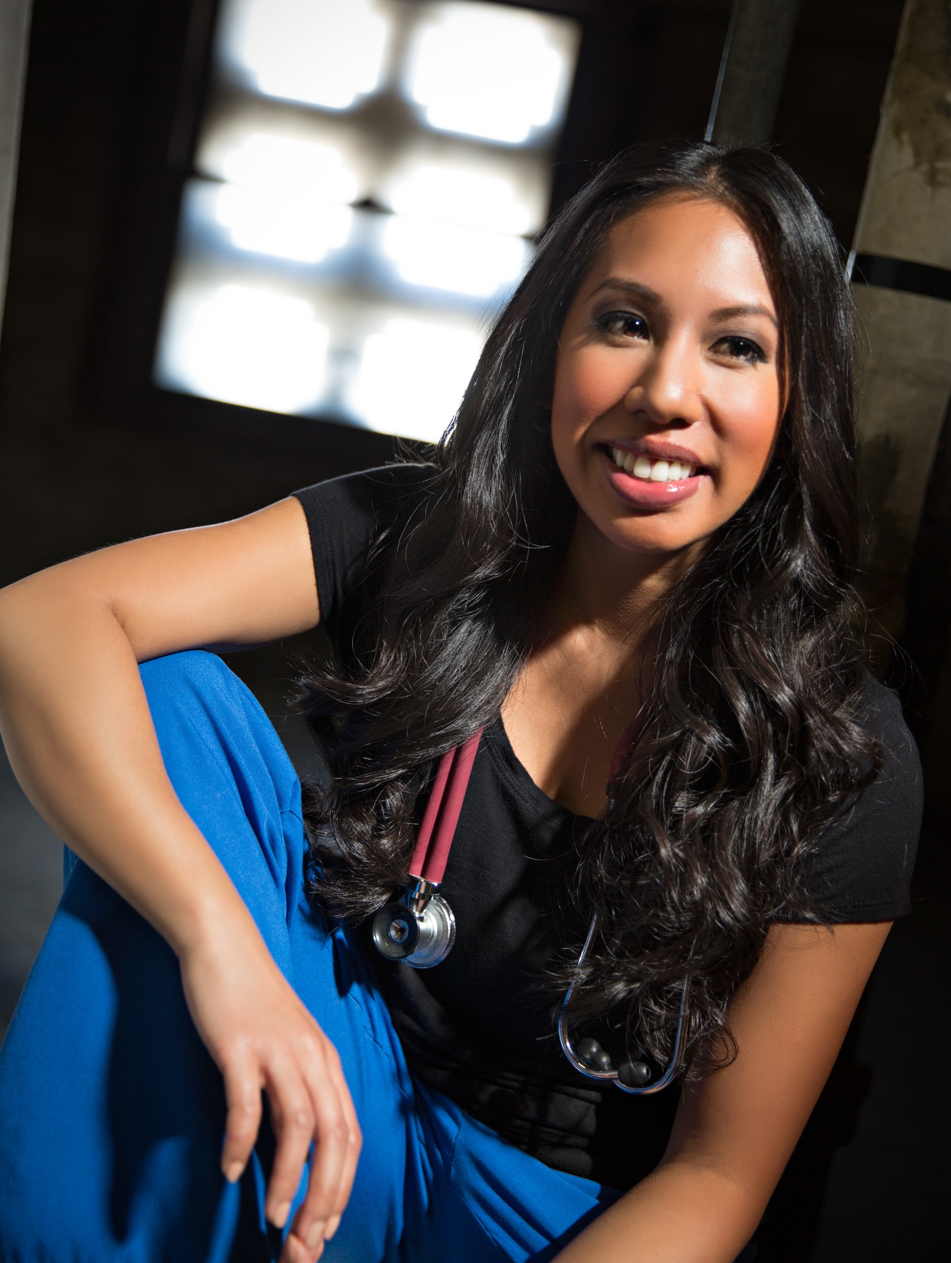 Healthcare professional in blue scrubs smiling confidently indoors