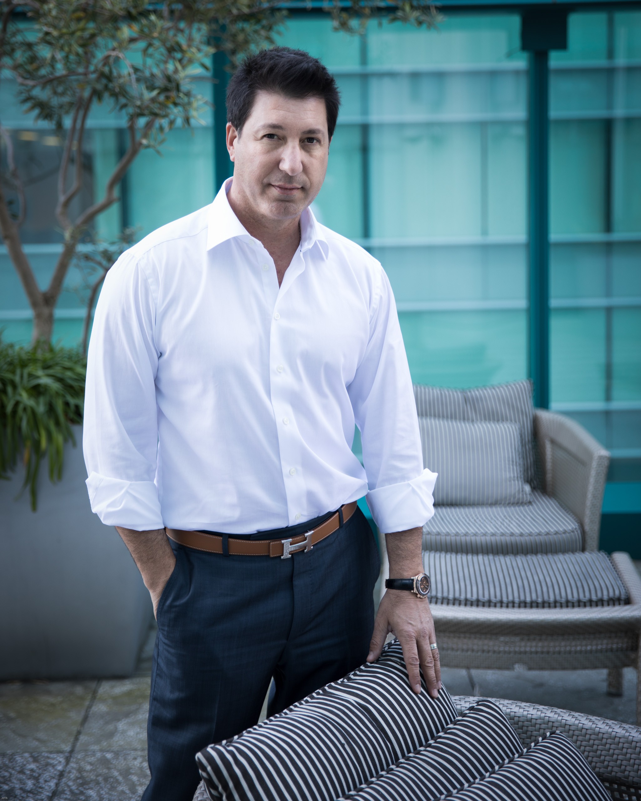 Professional man in white shirt posing in modern office courtyard