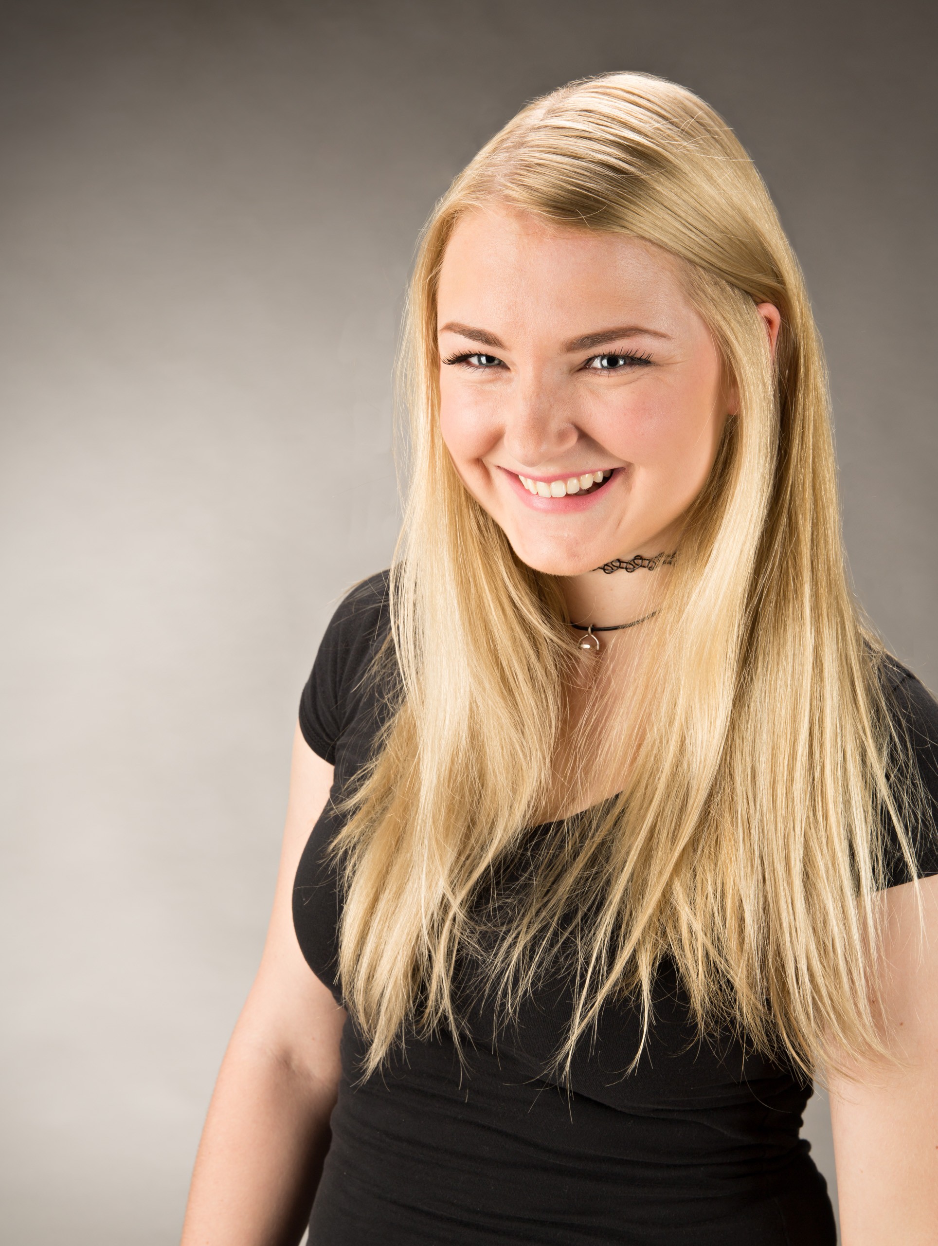 Professional headshot of smiling young woman with blonde hair