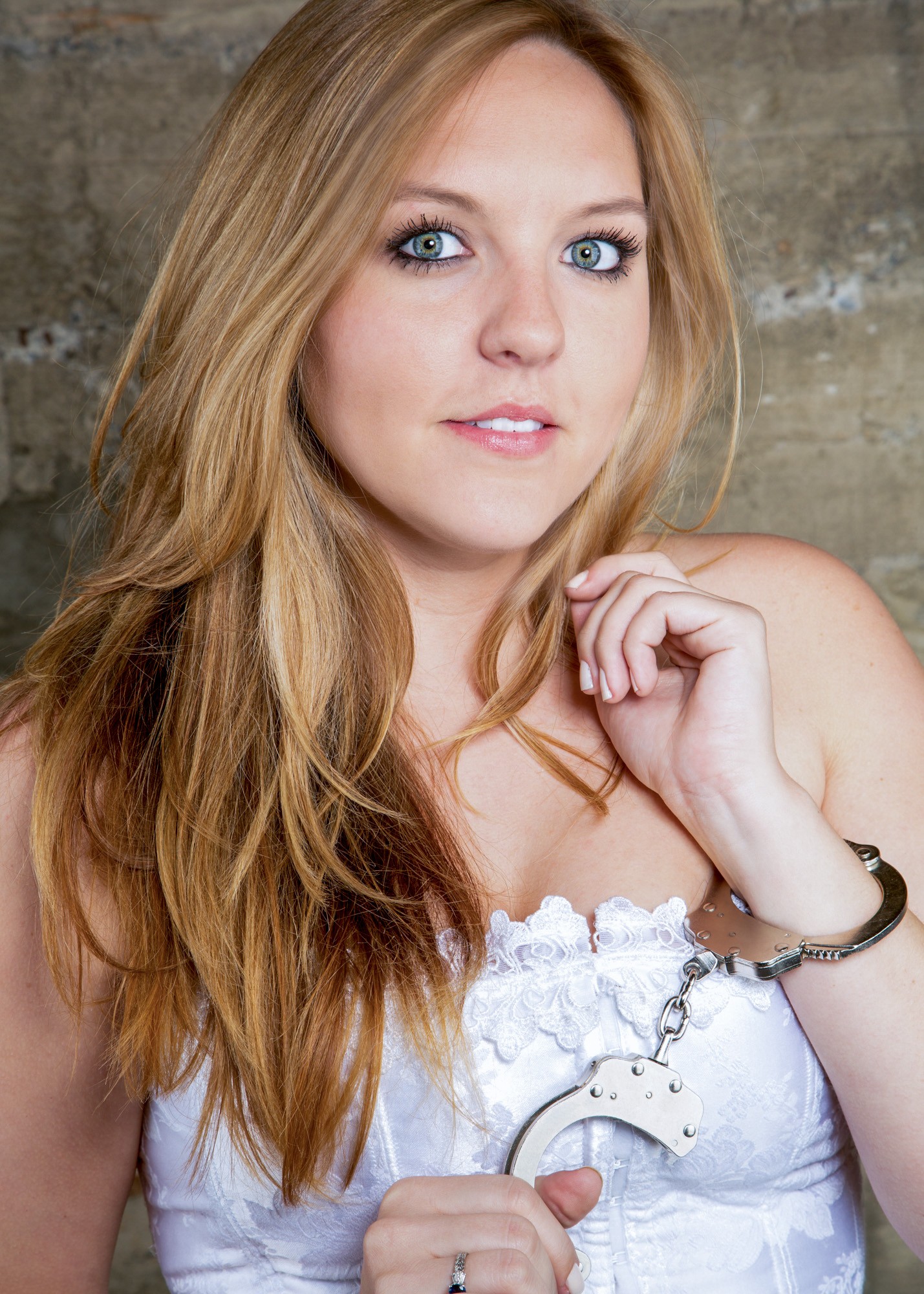 Professional portrait of woman with reddish-brown hair against textured gray backdrop
