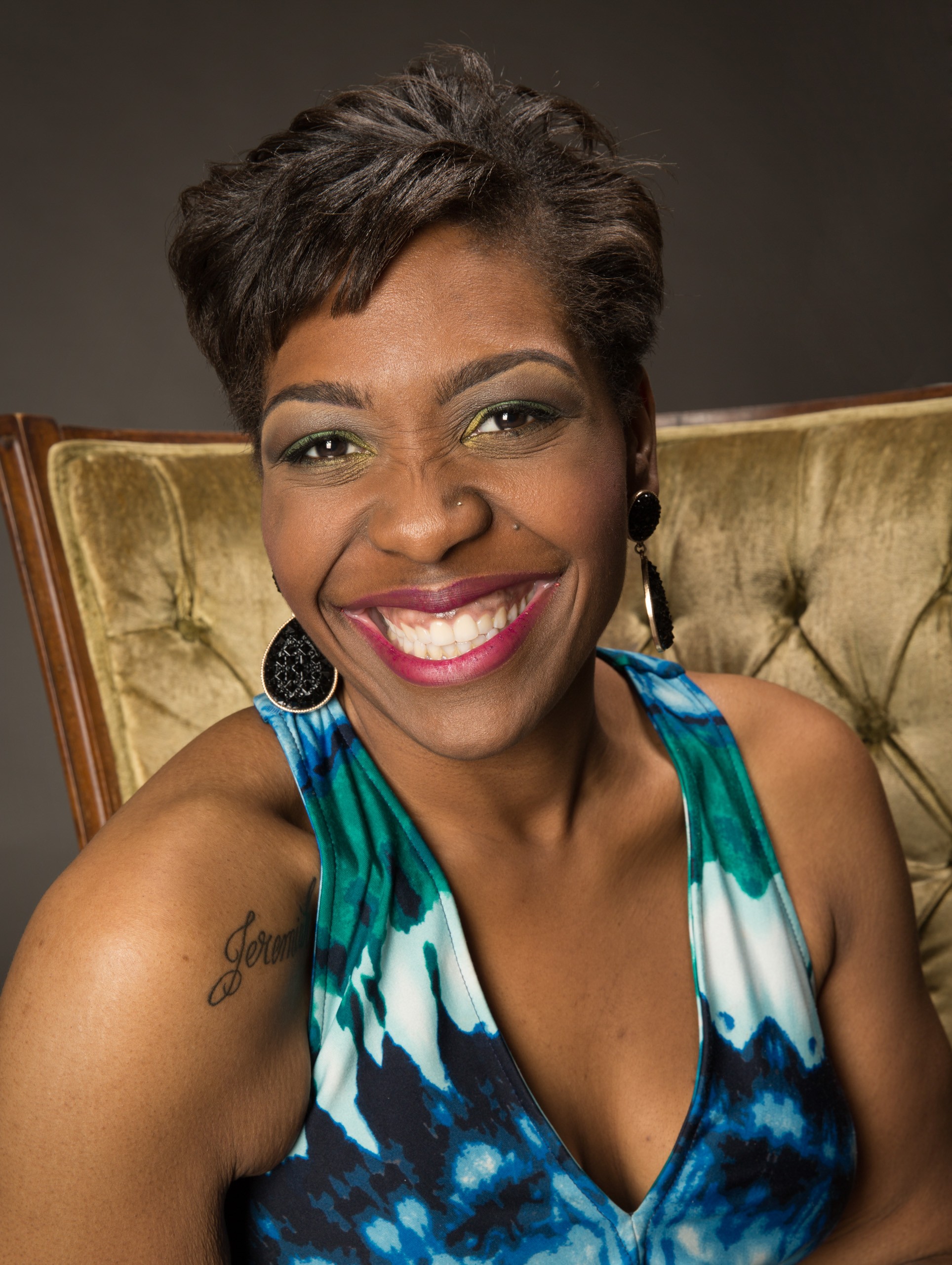 Professional headshot of smiling woman in blue patterned top