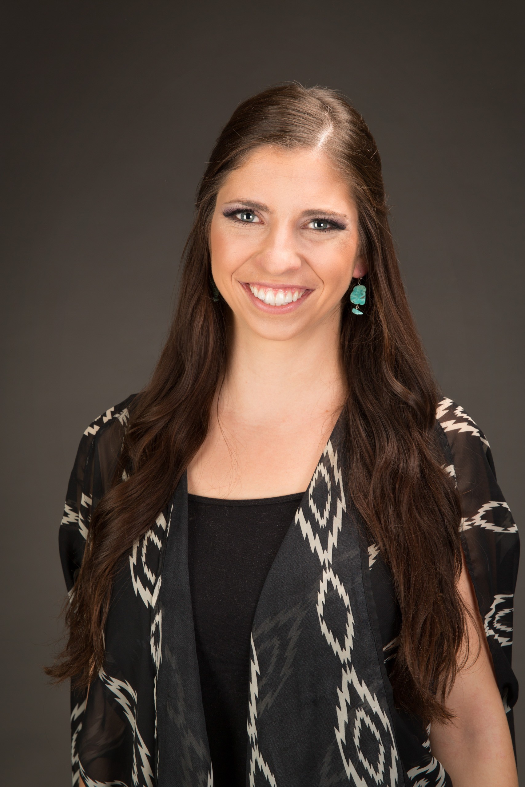 Professional headshot of smiling woman with long brown hair