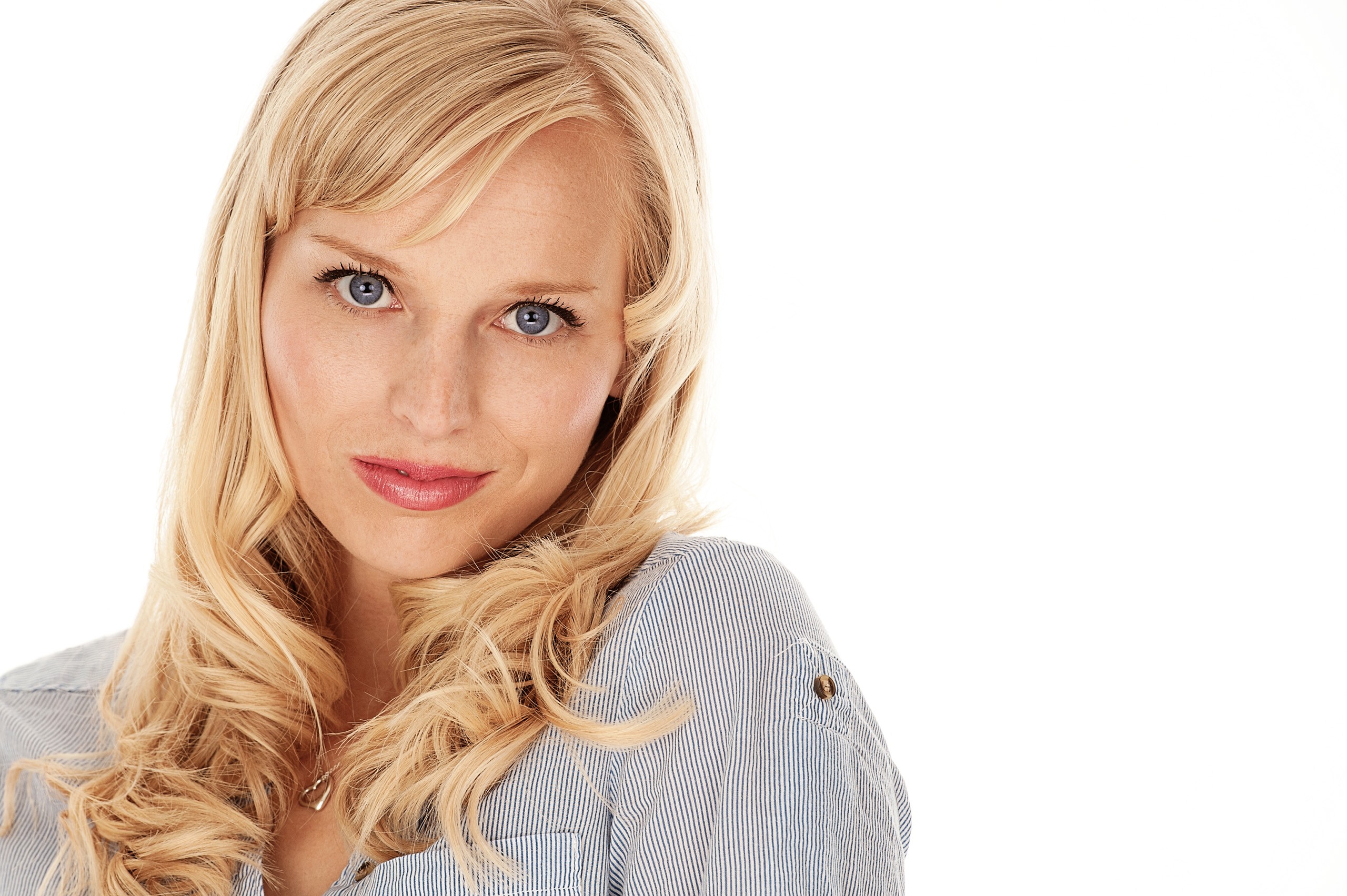 Professional headshot of blonde woman in light gray blouse, neutral background